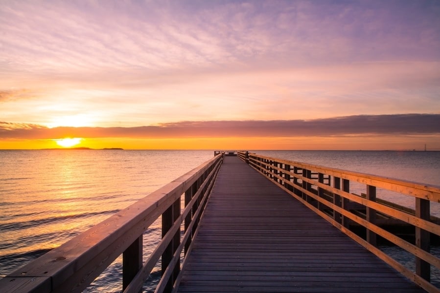jetée au bord de la mer au coucher du soleil
