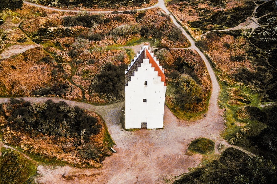 tour d’église blanche au milieu des dunes